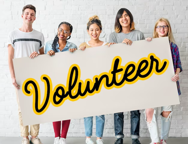 People holding a sign that says volunteer