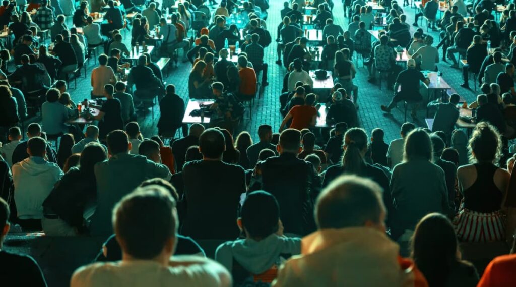 Crowds dining and socializing at an outdoor evening event